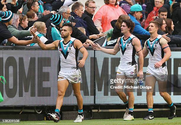 Jarman Impey Darcy Byrne-Jones and Hamish Hartlett of the Power celebrate the win with fans during the round 11 AFL match between the Collingwood...