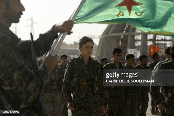 Syrian Kurds march during the funeral of fighters, who died during an assault launched by Arab and Kurdish forces against Islamic State group...