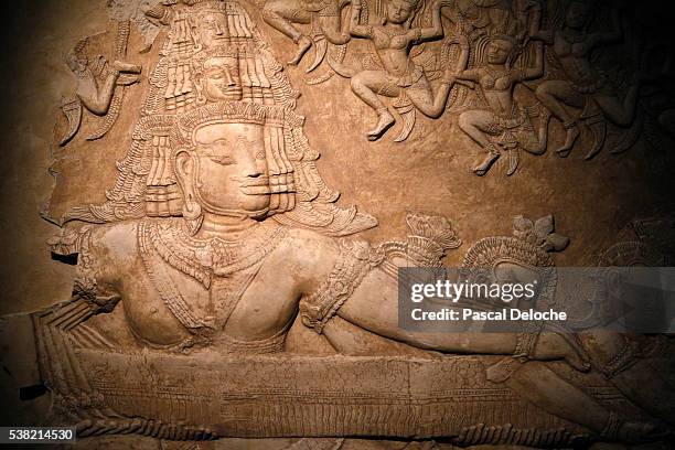 asura with multiple heads and arms holding the naga vasuki's body. cast of the "churning of the milk sea" law relief section. musée guimet. museum of asian arts. paris. exhibition: angkor birth of a myth. louis delaporte and cambodia. - guimet museum stock pictures, royalty-free photos & images