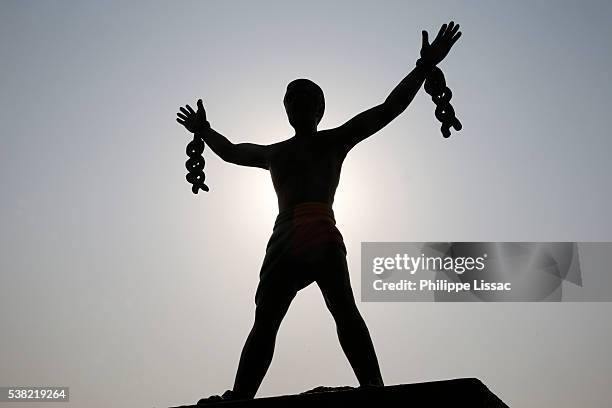 statue depicting a slave breaking his chains - freed slaves stockfoto's en -beelden