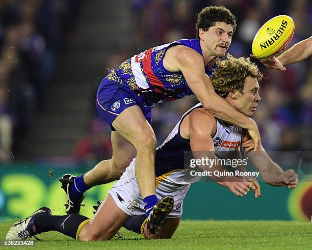 Matt Priddis of the Eagles handballs whilst being tackled by Tom Liberatore of the Bulldogs during the round 11 AFL match between the Western...