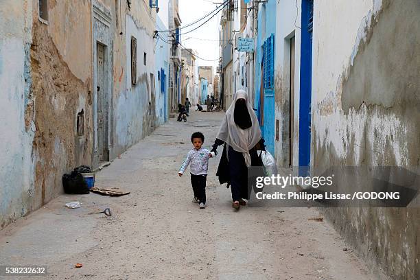 mother and son walking in the monastir medina (old town) - street monastir stock pictures, royalty-free photos & images