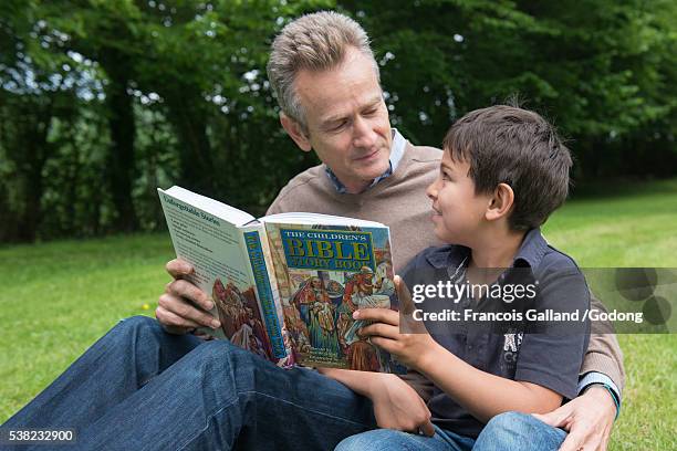 father and son reading a children's bible. - religious text fotografías e imágenes de stock