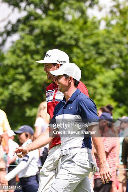 Rory McIlroy of Northern Ireland and Keegan Bradley laugh as they walk off the ninth hole tee box during the final round of the Memorial Tournament...