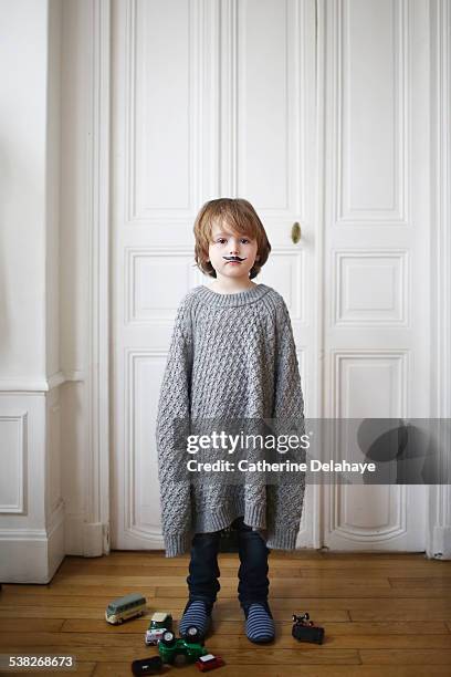 a boy wearing a moustache and a too long sweater - kid in big shoes stock pictures, royalty-free photos & images