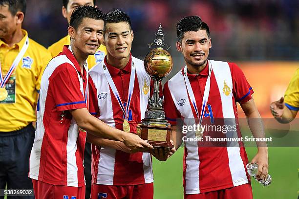 Prakit Deeprom, Sarach Yooyen and Kriekrit Thawikan of Thailand poses with the trophy during the 44th Kings Cup Final match between Jordan and...