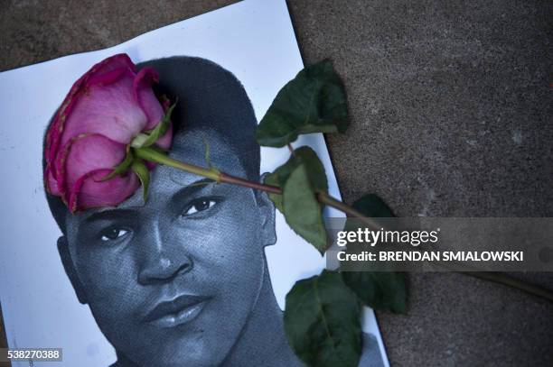 Flower and a image of Muhammad Ali are seen as people leave items to pay their respects to boxing legend Muhammad Ali at the Muhammad Ali Center June...