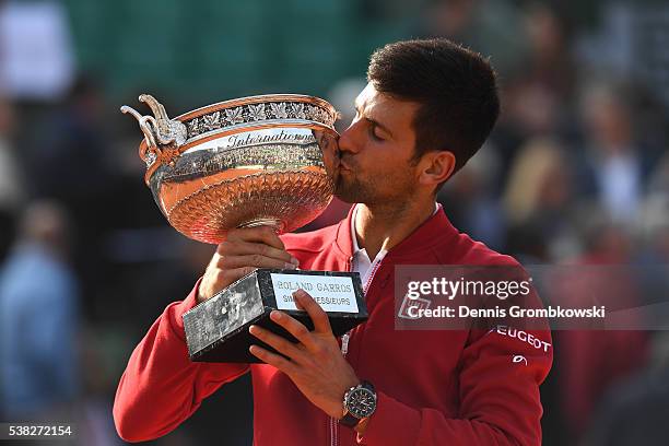 Champion Novak Djokovic of Serbia kisses the trophy following his victory during the Men's Singles final match against Andy Murray of Great Britain...
