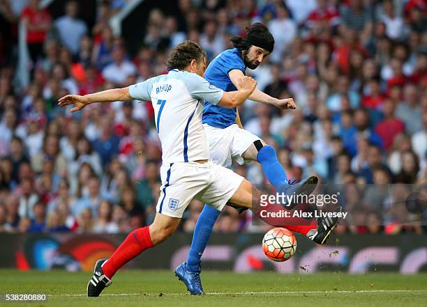 Sergio Pizzorno of Rest of the World shoots past John Bishop of England during the Soccer Aid 2016 match in aid of UNICEF at Old Trafford on June 5,...