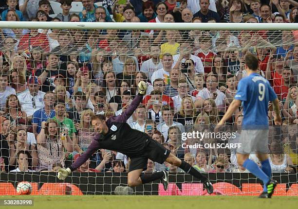 Former Bulgarian footballer Dimitar Berbatov scores a penalty past English presenter Jamie Theakston during the Soccer Aid charity football match...