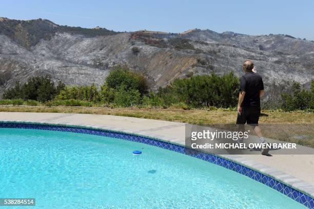 Richard Rosenberg looks at the burnt hills his home June 5, 2016 in Calabasas, California. - Some 5,000 people were evacuated from the brushfire...