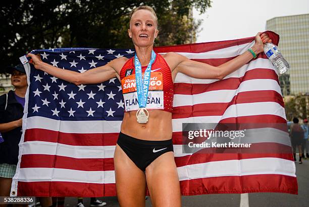 Time Olympian Shalane Flanagan poses with the Stars and Stripes flag after crossing the finish line setting her personal best time of 1:07:52 in the...