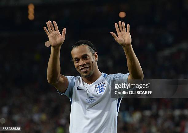 Former Brazilian footballer Ronaldinho waves on the pitch after the Soccer Aid charity football match between England and the Rest of the World at...