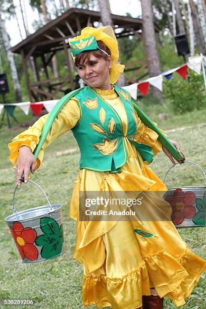 Woman carries buckets during the annual Sabantuy folk festival in Laishevo, Russia on June 05, 2016.