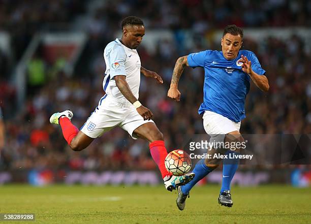 Jermaine Defoe of England beats Fabio Cannavaro of Rest of the World to score their second goal during the Soccer Aid 2016 match in aid of UNICEF at...