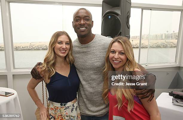 Actor B.J. Britt poses with guests during the Lifetime "UnREAL" Group Date and Champagne Brunch Aboard Dandeana Yacht With Cast and Executive...