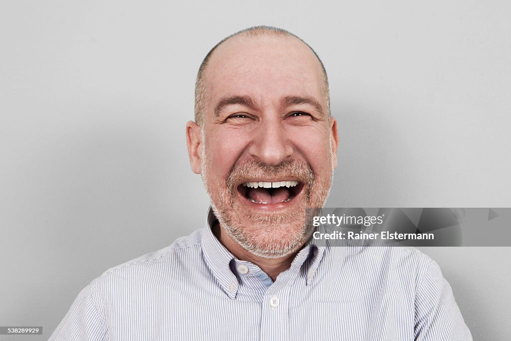 Portrait of middle aged man hysterically laughing