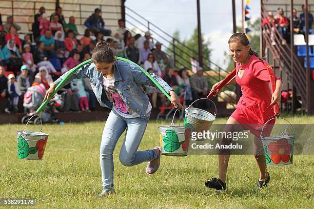 Two girls compete with buckets during the annual Sabantuy folk festival in Laishevo, Russia on June 05, 2016.