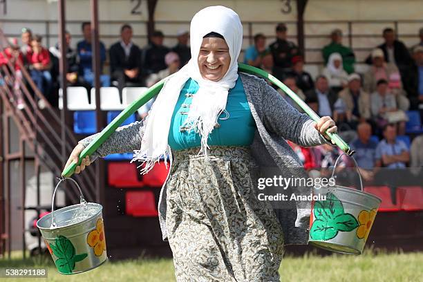 Woman competes with buckets during the annual Sabantuy folk festival in Laishevo, Russia on June 05, 2016.