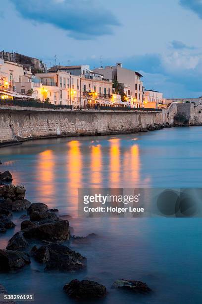 restaurants and bars in old town at dusk - siracusa stock pictures, royalty-free photos & images