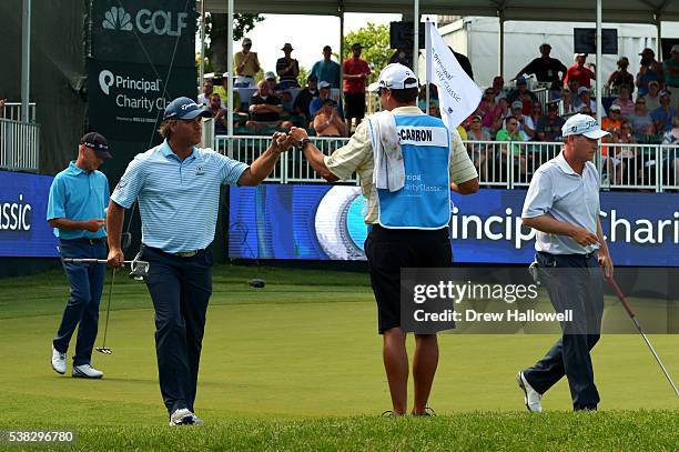 Scott McCarron fist pumps his caddie after making birdie on the 17th hole during the final round of the Principal Charity Classic at the Wakonda Club...