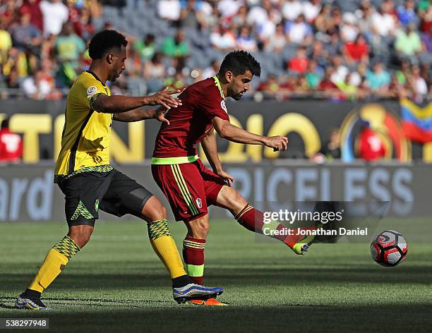 Tomas Rincon of Venezuela passes the ball under presure from Giles Barnes of Jamaica during a match in the 2016 Copa America Centenario at Soldier...