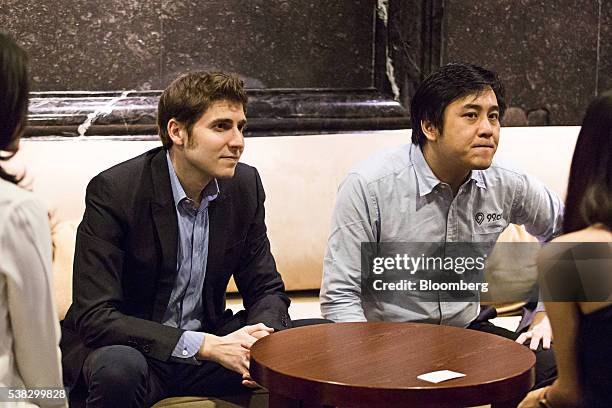 Billionaire Eduardo Saverin, co-founder of Facebook Inc., left, and Darius Cheung, founder and chief executive officer of 99.co, listen during an...