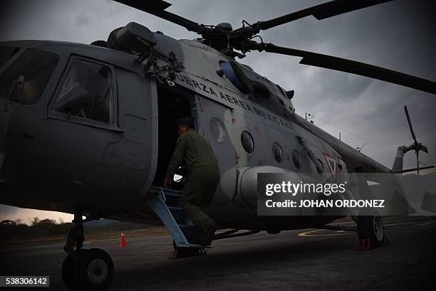 Members of the Mexican Air Force load a helicopter with equipment to spray water over wildfires tearing through the Maya Biosphere Reserve, at the...