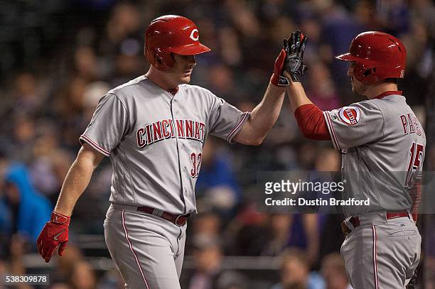 Jay Bruce of the Cincinnati Reds celebrates with Jordan Pacheco after hitting a sixth inning solo homerun against the Colorado Rockies at Coors Field...