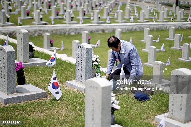 Man visits the grave of a relative who died during the Korean War at the Seoul national cemetary on June 6, 2016 in Seoul, South Korea. South Korea...
