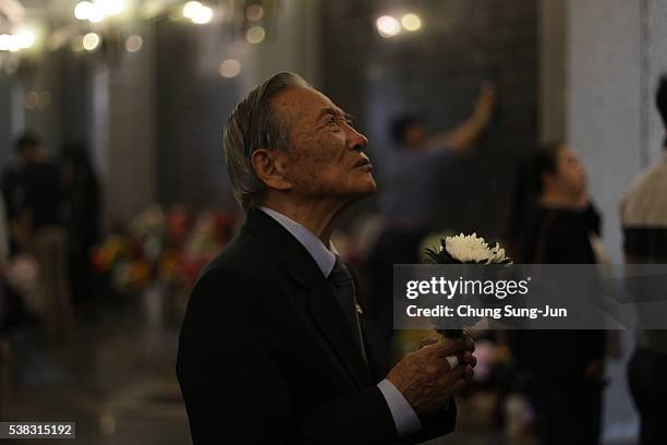 South Korean man holds flowers as he visits at Seoul national cemetary during a ceremony marking Korean Memorial Day at the Seoul National Cemetery...