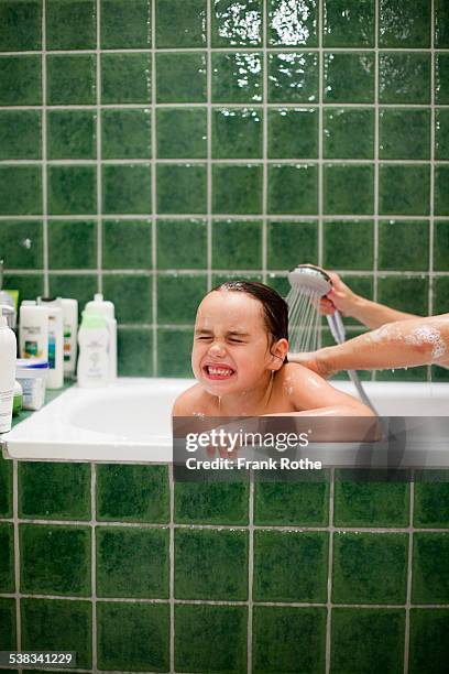 child in the bath gets here hair washed - woman bath tub wet hair stock pictures, royalty-free photos & images