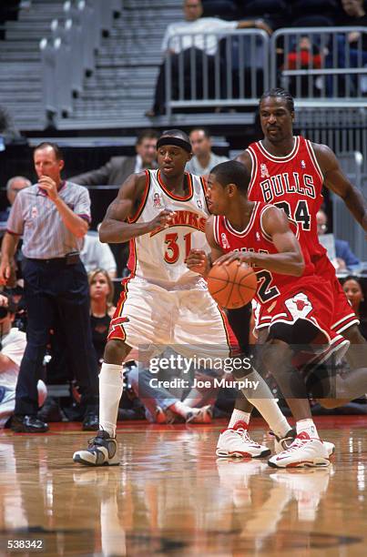 Guard Kevin Ollie of the Chicago Bulls dribbles away from guard Jason Terry of the Atlanta Hawks during the pre-season game at Phillips Arena in...