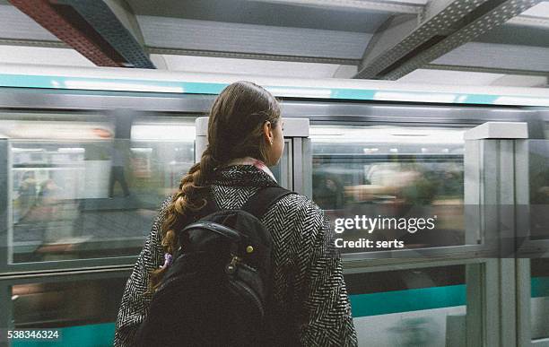 young woman waiting the train in paris subway station - paris metro sign stockfoto's en -beelden