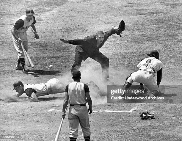 Umpire Frank Dascoli calls Bill Mazeroski of the Pittsburgh Pirates safe at the plate as the ball gets by LA Dodgers catcher John Roseboro, Los...
