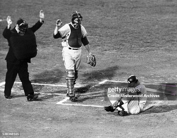 Dodgers' Willie Davis rolls on the ground after getting hit by a pitch as umpire Jocko Conlan and Chicago Cub catcher Sammy Taylor raise their hands...