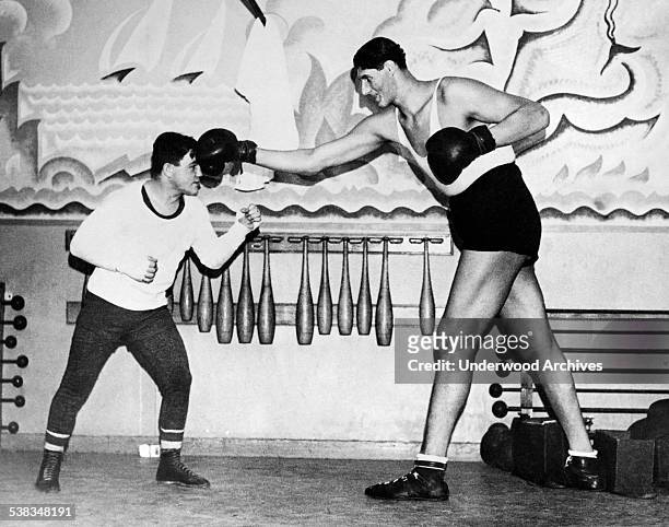 World welterweight champion Canadian Lou Boruillard does a bit of unequal sparring with Romanian heavyweight boxer Gogea Mitu, the world's tallest...