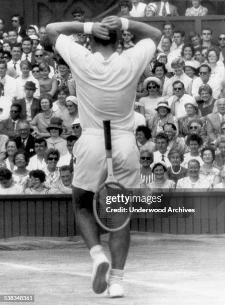 American tennis player Chuck McKinley drops his racquet and faces the crowd during the men's semi-finals at Wimbledon, London, England, July 6, 1961....