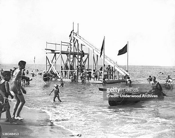 Busy day on the floating diving boards and water chute at Deauvile, the stylish English Channel resort, Deauville, England, August 1933.