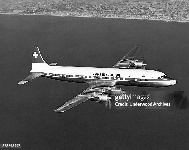 Swiss Air Douglas DC-7C flying along the Southern California coastline, California, January 1957.
