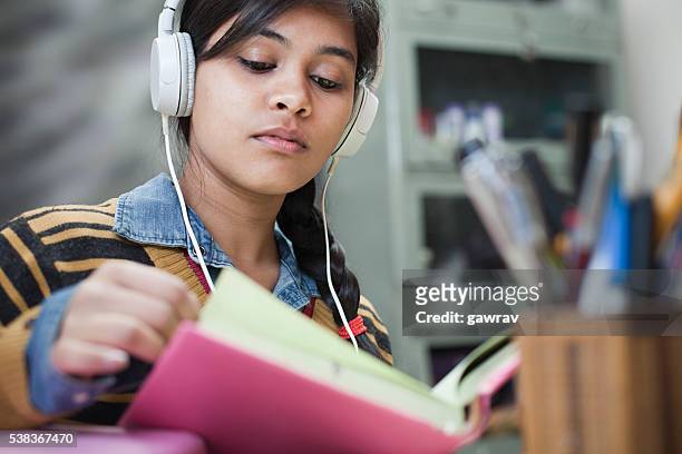 fine giovani ragazza studentessa studiando e ascoltare musica. - sfogliare libro foto e immagini stock