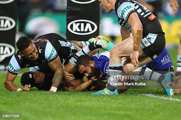 Michael Ennis and Ben Barba s fail to stop Sam Kasiano of the Bulldogs as he scores a try during the round 13 NRL match between the Canterbury...