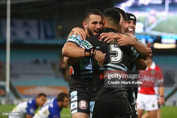 Jack Bird, Valentine Holmes and Michael Ennis of the Sharks celebrate Holmes scoring a try during the round 13 NRL match between the Canterbury...