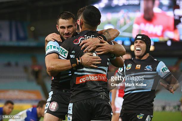 Jack Bird, Valentine Holmes and Michael Ennis of the Sharks celebrate Holmes scoring a try during the round 13 NRL match between the Canterbury...