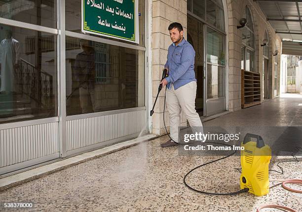 Sweileh, Jordan A young man cleans the floor in front of a mosque with a high pressure cleaner on April 08, 2016 in Sweileh, Jordan .