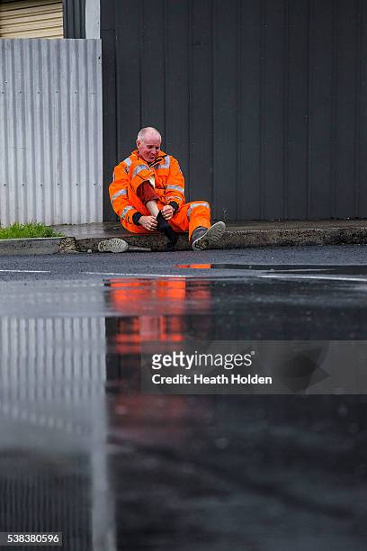An SES worker wrings out wet socks during the day as the evacuation of residents continues after the Mersey River breaks its banks and floods several...