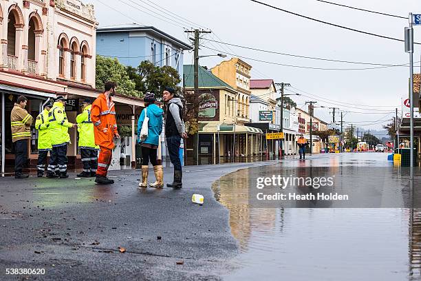 Locals and tourists assess the extent of the damage after the Mersey River breaks its banks and floods several small towns cutting of road access...