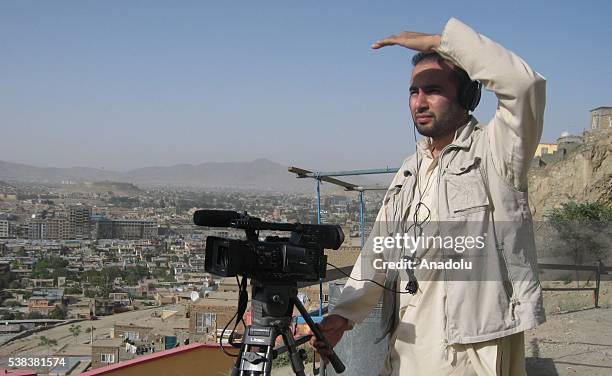 This photograph taken on July 8 shows Anadolu Agency and National Public Radio interpreter Zabihullah Tamanna as he films a report on the outskirts...