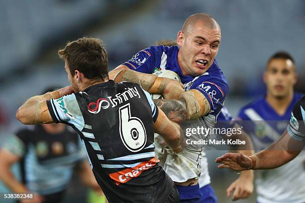 James Maloney of the Sharks is bumped off by David Klemmer of the Bulldogs during the round 13 NRL match between the Canterbury Bulldogs and the...