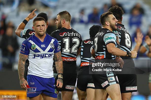 Craig Garvey of the Bulldogs looks dejected as Jack Bird of the Sharks celebrates victory during the round 13 NRL match between the Canterbury...